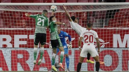 El defensa francés del Sevilla, Jules Koundé (2d), intenta rematar un balón ante el defensa del Betis, Marc Bartra (2i), durante el encuentro correspondiente a la jornada 28 de primera división