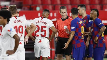 El arbitro del encuentro, González González (C) conversa con el delantero uruguayo del FC Barcelona, Luis Suárez (3d)