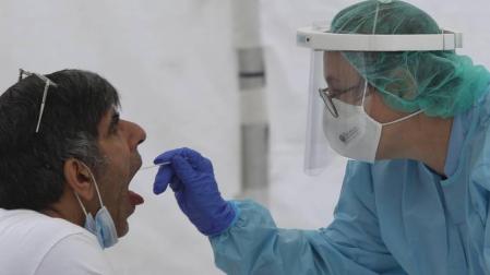 Una sanitaria le realiza un frotis bucal a un vecino de Ordizia en una de las carpas instaladas en el parque Barrena por el Ayuntamiento de Ordizia para realizar test ante el posible brote de COVID-19 detectado en la localidad guipuzcoana.