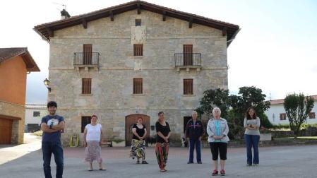 Desde la izquierda, Iñigo Landibar Goñi, María Pilar y María Jesús Beraza Huarte, Ainhoa Azkue Mínguez, Cruz Oteiza Bustingorri, Maritxu Irure Recalde, y María Manso Montes, frente a Casa Fructoso, ejemplo de la arquitectura de la zona.