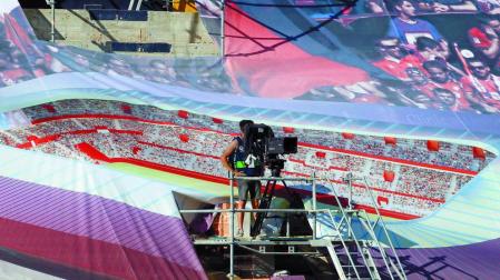Un cámara de televisión, durante el Osasuna-Getafe, situado en una de las gradas de El Sadar que están tapadas actualmente con lonas que proyectan el estadio reformado y ampliado.