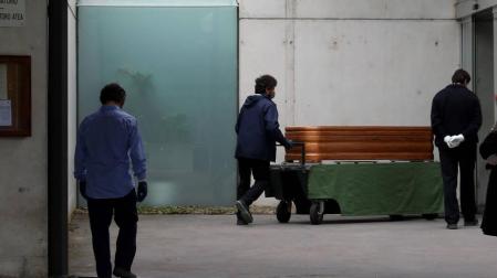 Operarios del cementerio de Pamplona trasladan un féretro el pasado sábado por la mañana.