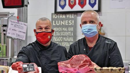 Mikel Aldave y César Salón, de la carnicería Abaurrea, posando ayer con carne de toro en su puesto del mercado de Santo Domingo.