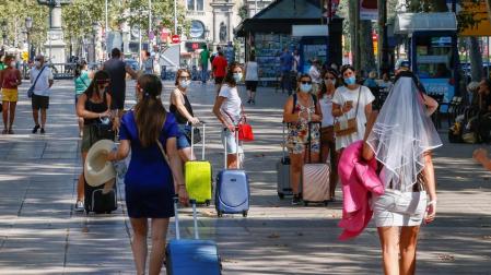 Varias turistas caminan por las Ramblas de Barcelona.