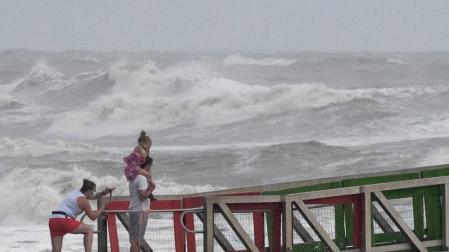 Una familia observa el mar en la llegada del huracán 'Hanna' a Texas