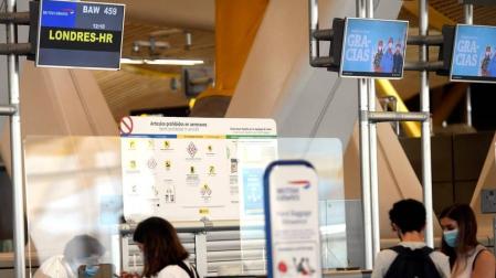 Jóvenes en la ventanilla de facturación para un vuelo con destino Londres, en la terminal T4 del Aeropuerto de Madrid-Barajas