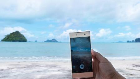 Foto de persona haciendo foto con el móvil en una playa