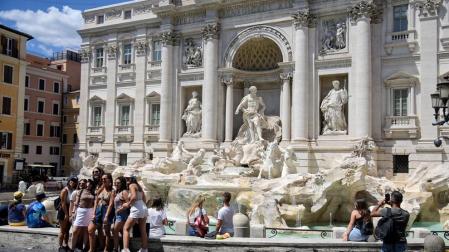 Varios turistas se fotografían en la Fontana de Trevi con mascarilla