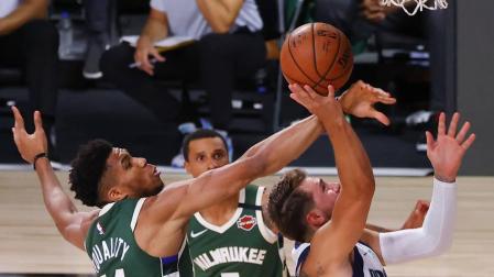 Antetokounmpo trata de bloquear a Doncic.