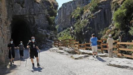 Diversos grupos de senderistas recorren, con la mascarilla puesta, la foz de Lumbier, uno de los atractivos naturales de la villa.