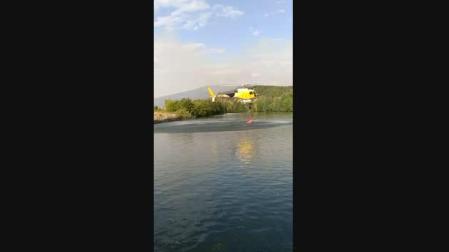 Un helicóptero de extinción cogiendo agua en la laguna del aserradero de Ekai