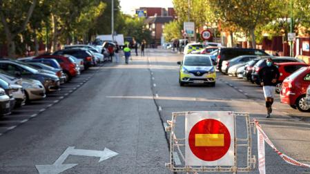 Una señal de prohibido el paso colocada junto a una patrulla de la policía local en la calle Miraflores de la localidad madrileña de Alcobendas.