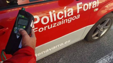 Un agente con un etilómetro indiciario en un control de alcoholemia.