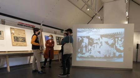 Asistentes a la inauguración de la muestra junto a una reproducción del 'Guernica' de Picasso.