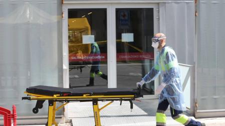 Un profesional sanitario traslada una camilla a la zona de desinfección del Hospital de Navarra (CHN).