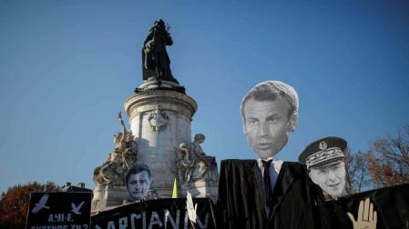 Manifestación en París con la imagen de Macron en una pancarta.