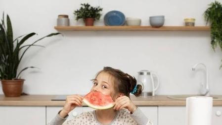 Imagen de una niña comiendo sandía