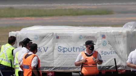 Operarios descargan un avión de Aerolíneas Argentinas contenedores de la vacuna rusa Sputnik V.