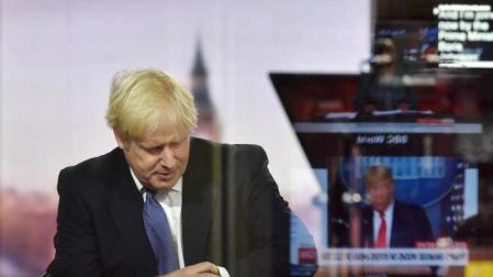 Boris Johnson consulta su reloj durante una entrevista en la BBC.