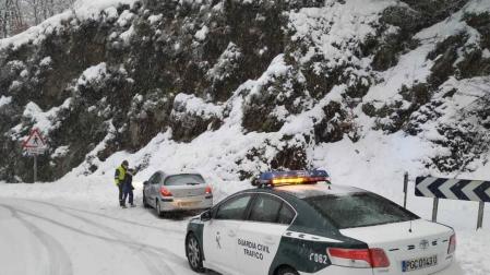 Imagen de un coche de la Guardia Civil auxiliando a otro vehículo en Ibañeta.