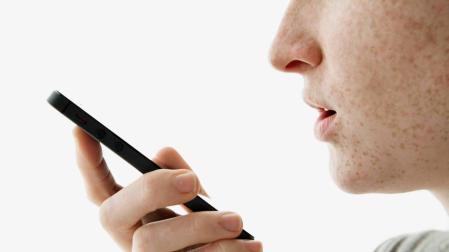 Un joven da instrucciones a un móvil a través de un asistente virtual.