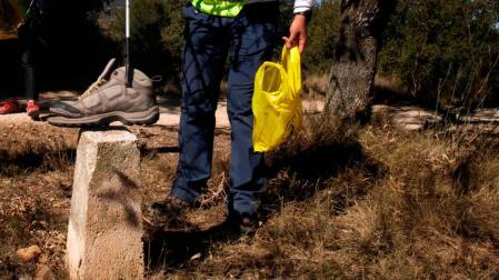 Una persona recoge basura en el Camino de Santiago.