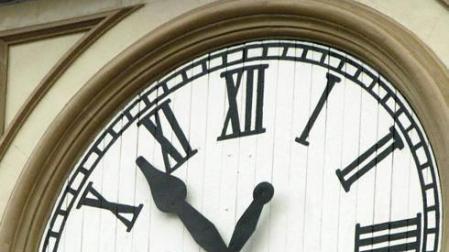 Un operario cambiando la hora de un reloj.
