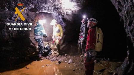 Guardia Civil y los espeleólogos, junto a la bolsa de explosivos en el interior de la cueva.