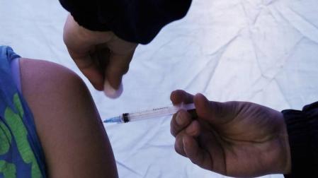 Una persona es vacunada contra el coronavirus en Chile.