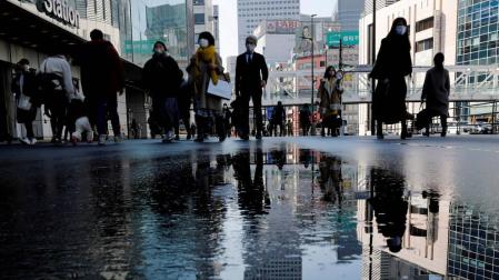 Ciudadanos japoneses con mascarilla pasean por una calle de Tokyo antes del terremoto