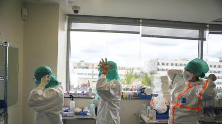 Profesionales médicos se preparan antes de entrar a la UCI en el Hospital de La Paz de Madrid.