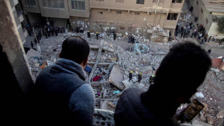 Dos personas observan las labores de rescate tras el derrumbe de un edificio de viviendas en Gesr Al Suez, El Cairo, Egipto.