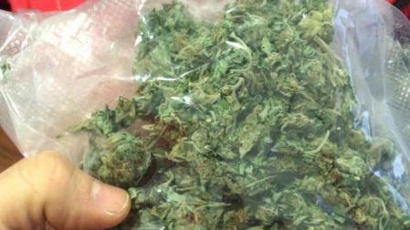 Un agente sostiene la bolsa de marihuana incautada.
