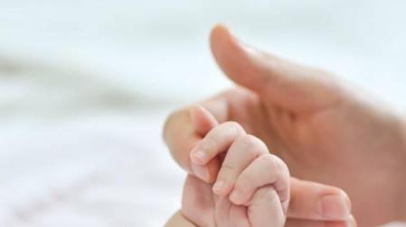 Imagen de la mano de un bebé sobre la mano de su madre