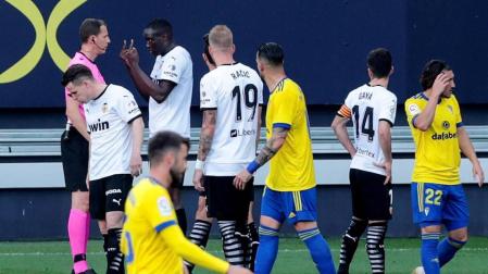 El defensa del Valencia Mouctar Diackhaby conversa con el árbitro Medié Jiménez momentos antes de abandonar el terreno de juego por un insulto racista de Juan Cala