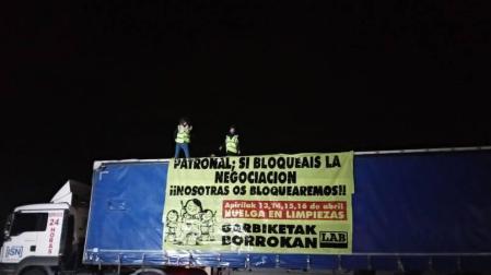 Dos trabajadoras de limpiezas se sube a un camión en protesta por el convenio