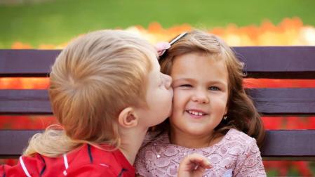 Un niño besa a una niña