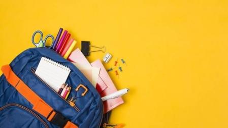 Imagen de una mochila junto a varios artículos de material escolar