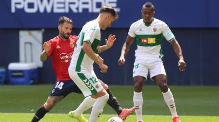 Rubén García pelea por un balón con dos rivales del Elche.