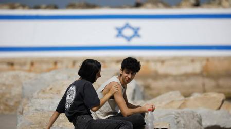Dos ciudadanos israelíes disfrutan de poder estar al aire libre sin mascarilla.