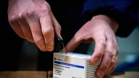 Un trabajador de un centro logístico holandés manipula una caja de firma.