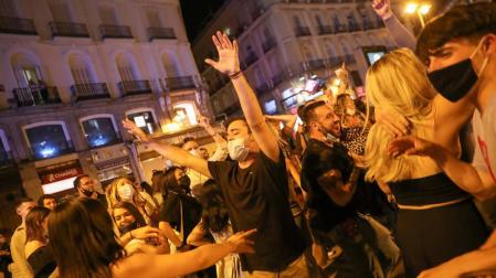 Jóvenes en Madrid celebran el final del toque de queda en la Puerta del Sol.