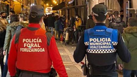 Agentes de Policía Municipal y Policía Foral patrullan por las calles de Pamplona.