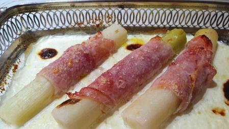 Puerros envueltos en jamón con salsa de nata y comino