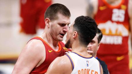 Nikola Jokic discute con Devin Booker.