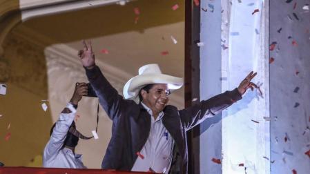 El candidato presidencial peruano Pedro Castillo saluda a sus seguidores en el balcón de la sede central de su partido, en Lima.