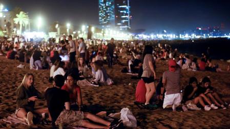 Varias personas celebran en la playa de la Barceloneta la noche de San Juan
