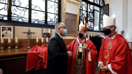 El alcalde de Pamplona Enrique Maya (i) saluda al Arzobispo de Pamplona Francisco Pérez (c) antes de oficiar la misa en la parroquia de San Lorenzo este miércoles 7 de julio.