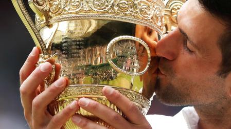 Novak Djokovic besa el trofeo que le acredita como vencedor de Wimbledon 2021
