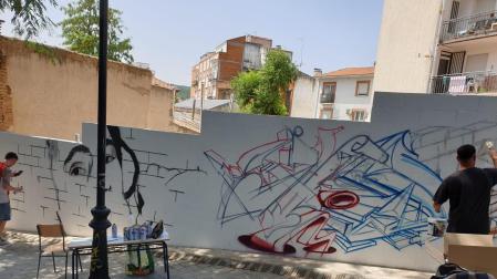 Varios grafiteros decoran una de las fachadas de la localidad madrileña de San Martín de Valdeiglesias.